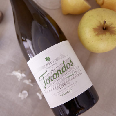 Botella Gran Torondos Verdejo en una mesa con limones y flores