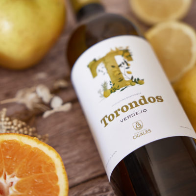 Botella Torondos Verdejo en una mesa con frutas.