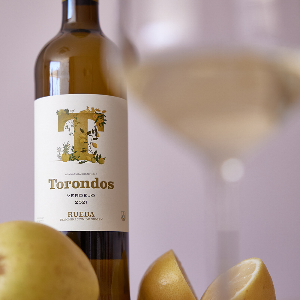 Botella Torondos Verdejo Rueda con copa de vino un limón y una manzana